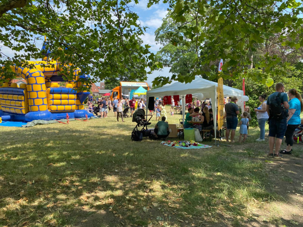 Bunte Hüpfburg und Menschen auf Festplatz
