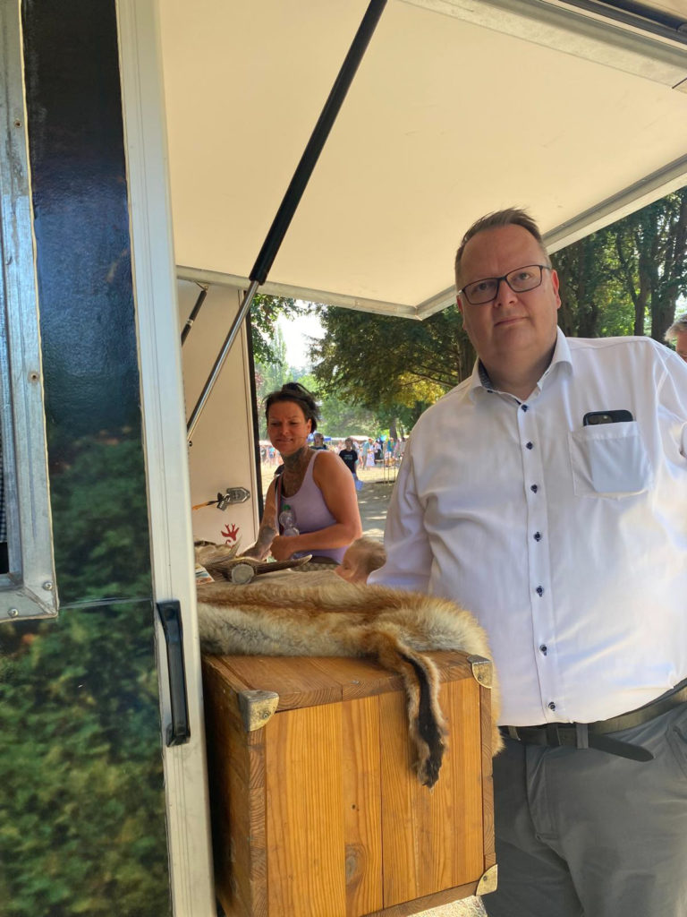 Mann am Stand mit Tierfellen.